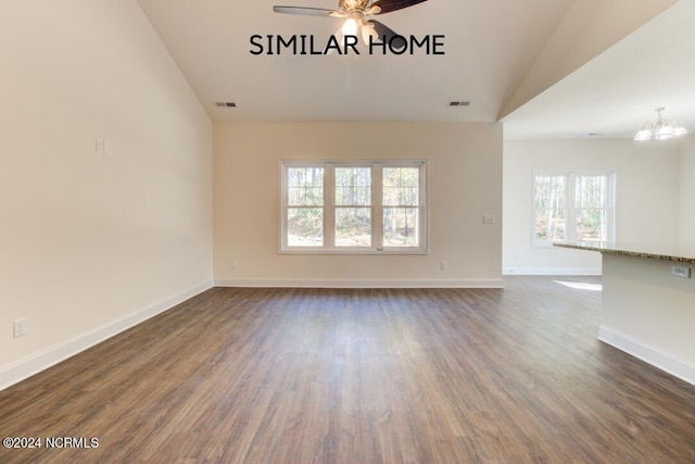 unfurnished room with dark hardwood / wood-style floors, ceiling fan with notable chandelier, and vaulted ceiling