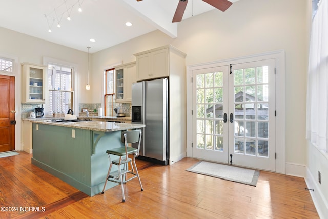 kitchen with light hardwood / wood-style flooring, stainless steel appliances, a breakfast bar, and a kitchen island