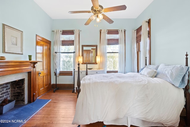 bedroom with ceiling fan, multiple windows, and light wood-type flooring