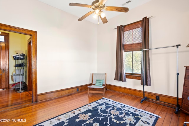 sitting room with ceiling fan and wood-type flooring