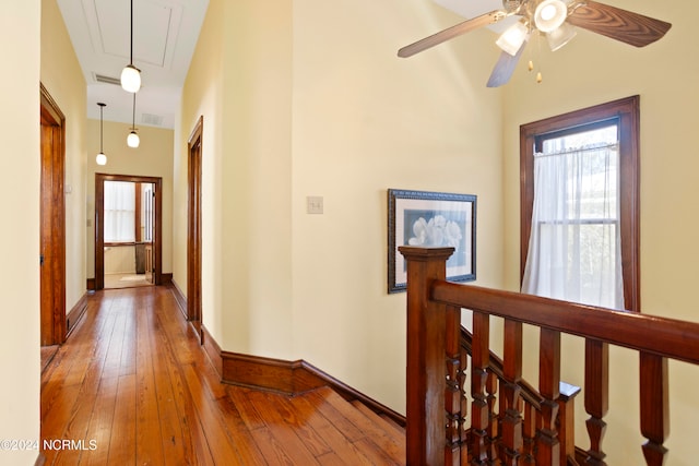 hallway with hardwood / wood-style floors and a high ceiling