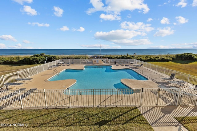 view of swimming pool featuring a patio area and a water view