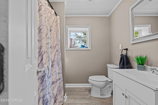 bathroom with vanity, wood-type flooring, a textured ceiling, crown molding, and toilet