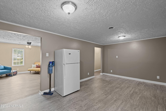 unfurnished living room with wood-type flooring, a textured ceiling, crown molding, and ceiling fan