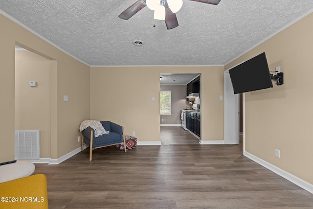 living area with ornamental molding, ceiling fan, hardwood / wood-style floors, and a textured ceiling