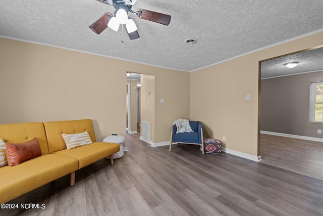 sitting room with wood-type flooring, ceiling fan, crown molding, and a textured ceiling