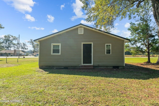 rear view of property featuring a yard