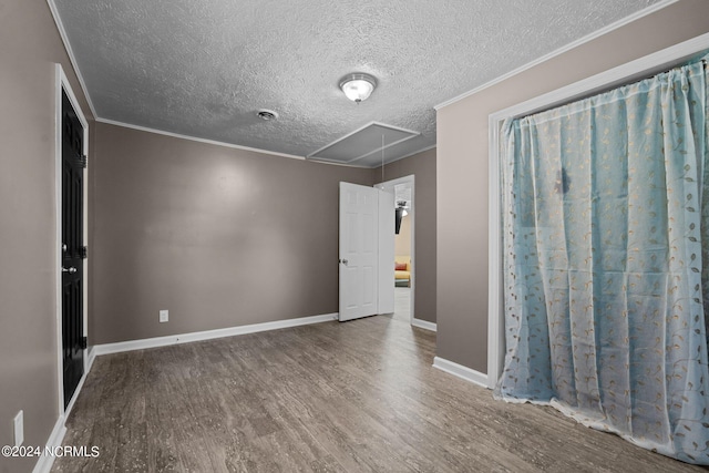 unfurnished room featuring wood-type flooring, a textured ceiling, and ornamental molding