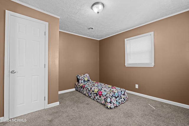 bedroom with ornamental molding, a textured ceiling, and carpet flooring