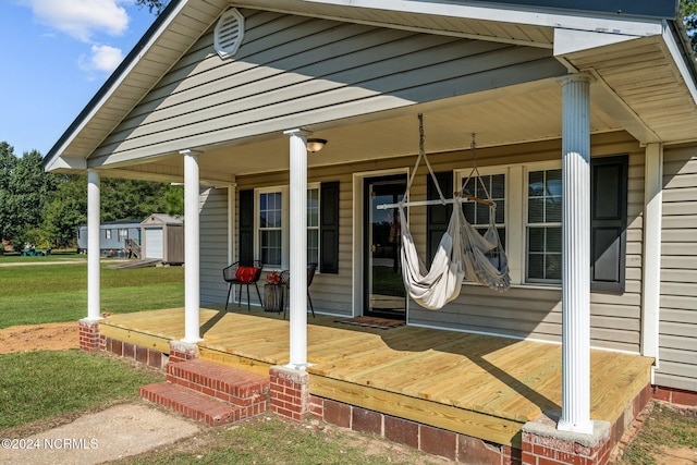 property entrance with covered porch and a lawn