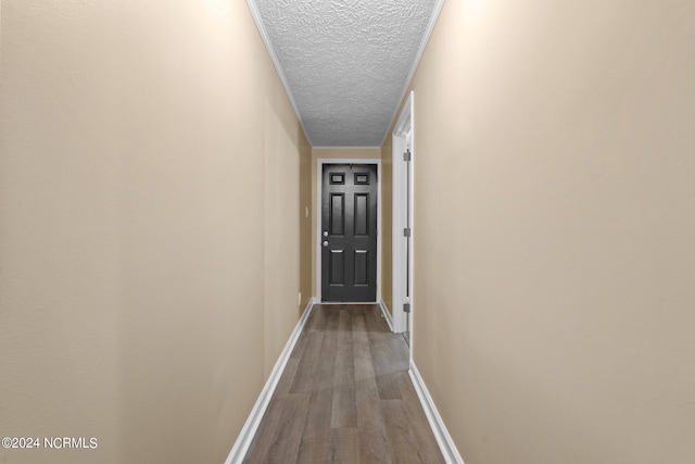 hall with a textured ceiling and hardwood / wood-style floors