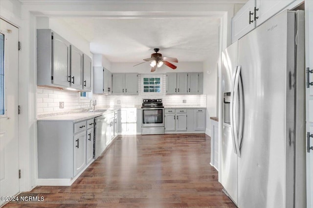 kitchen with sink, appliances with stainless steel finishes, dark hardwood / wood-style floors, and tasteful backsplash