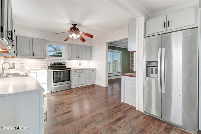 kitchen featuring tasteful backsplash, appliances with stainless steel finishes, sink, dark hardwood / wood-style flooring, and ceiling fan