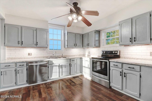 kitchen with ceiling fan, backsplash, dark wood-type flooring, sink, and stainless steel appliances