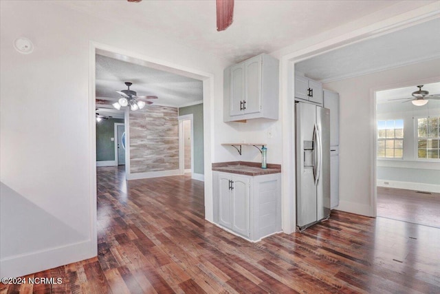 kitchen with white cabinetry, a textured ceiling, dark hardwood / wood-style flooring, and stainless steel fridge