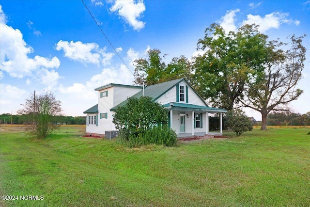 view of front of property with a porch, a front yard, and central AC unit