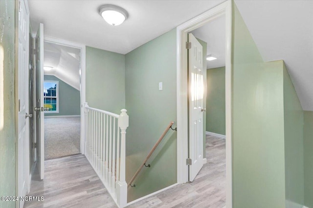 hall featuring lofted ceiling and light hardwood / wood-style flooring