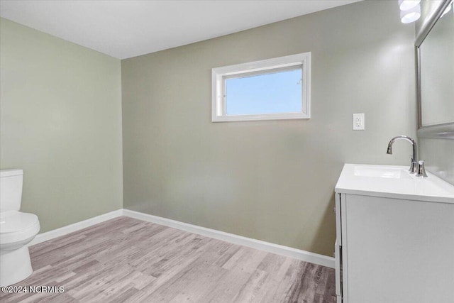 bathroom with vanity, toilet, and wood-type flooring