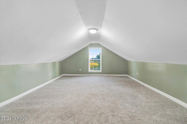 additional living space with vaulted ceiling and carpet floors