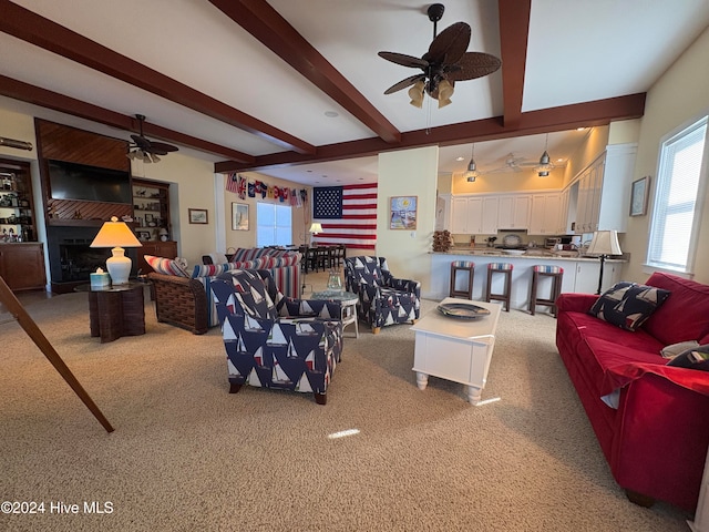 living room featuring ceiling fan, beamed ceiling, and carpet floors