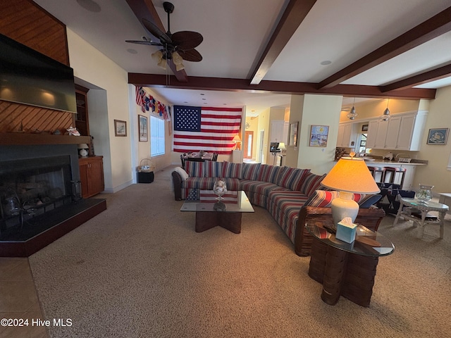 living room with beamed ceiling, light colored carpet, and ceiling fan