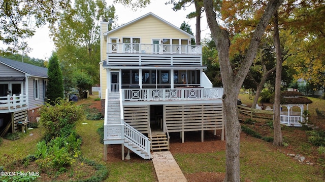 rear view of house featuring a deck and a sunroom