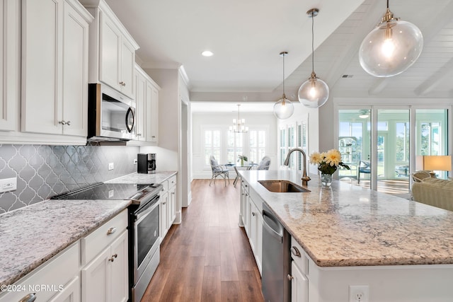 kitchen with white cabinets, appliances with stainless steel finishes, a healthy amount of sunlight, and an island with sink