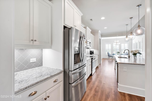 kitchen featuring hanging light fixtures, dark hardwood / wood-style flooring, white cabinetry, sink, and stainless steel appliances