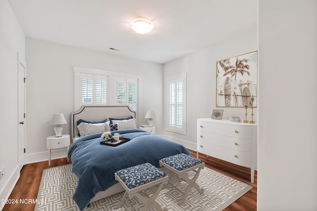 bedroom with dark hardwood / wood-style flooring