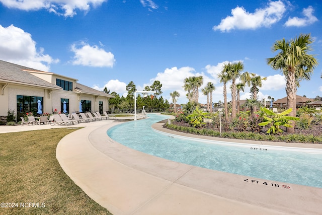 view of pool with a patio and a yard