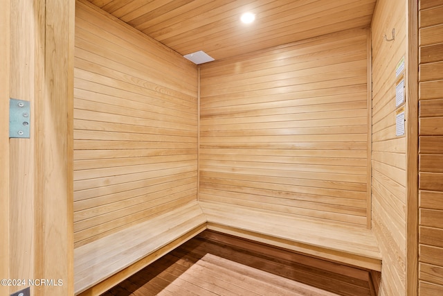 view of sauna featuring wood ceiling, wood-type flooring, and wooden walls