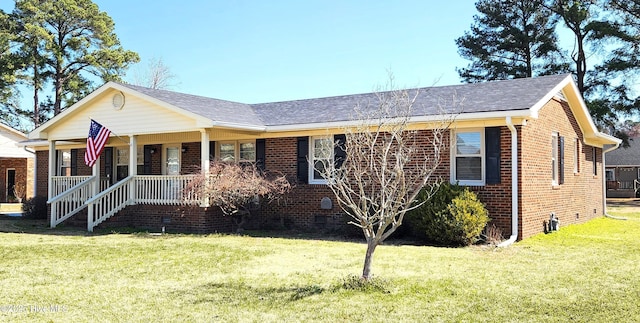 view of front of home featuring brick siding, a shingled roof, a porch, a front yard, and crawl space