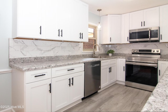 kitchen featuring a sink, tasteful backsplash, appliances with stainless steel finishes, and white cabinets