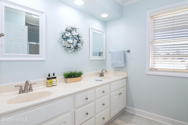 bathroom featuring double vanity, baseboards, tile patterned floors, and a sink