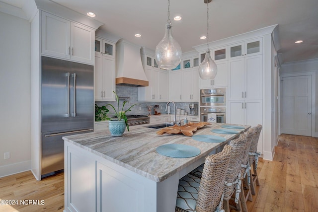 7 S Waterfront Pl, Hampstead, NC 28443 - kitchen with stainless steel appliances, custom exhaust hood, a sink, and white cabinetry