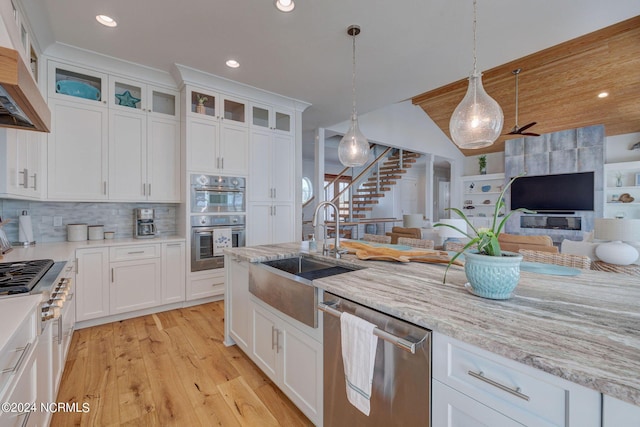 7 S Waterfront Pl, Hampstead, NC 28443 - kitchen featuring appliances with stainless steel finishes, a sink, light wood finished floors, white cabinetry, and open floor plan