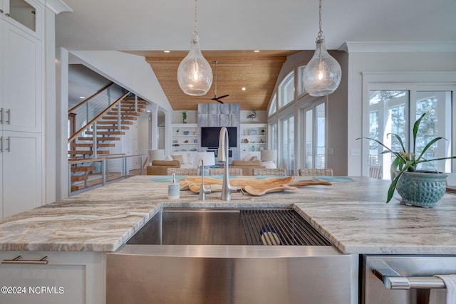 7 S Waterfront Pl, Hampstead, NC 28443 - kitchen with open floor plan, white cabinetry, light stone counters, a sink, and hanging light fixtures