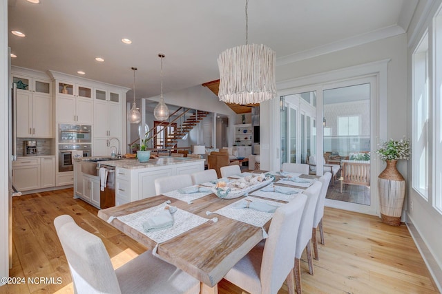 7 S Waterfront Pl, Hampstead, NC 28443 - dining area featuring an inviting chandelier, light wood-style floors, crown molding, and stairway