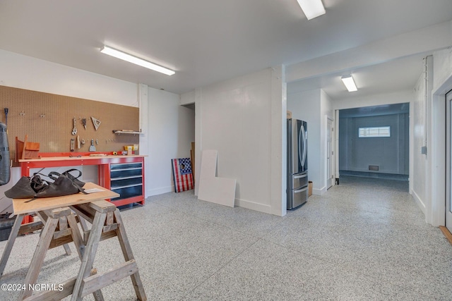 7 S Waterfront Pl, Hampstead, NC 28443 - basement featuring freestanding refrigerator, baseboards, and a workshop area