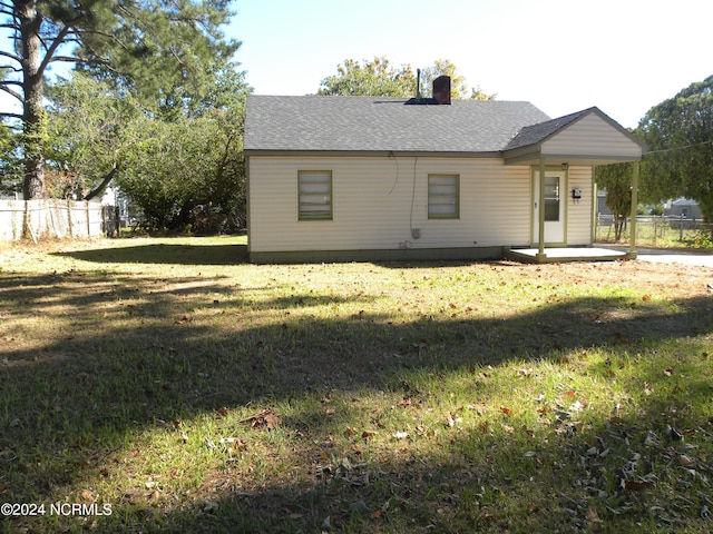 rear view of property featuring a lawn