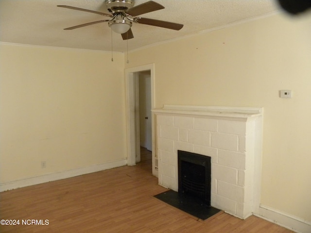 unfurnished living room featuring ceiling fan, ornamental molding, a textured ceiling, and hardwood / wood-style floors