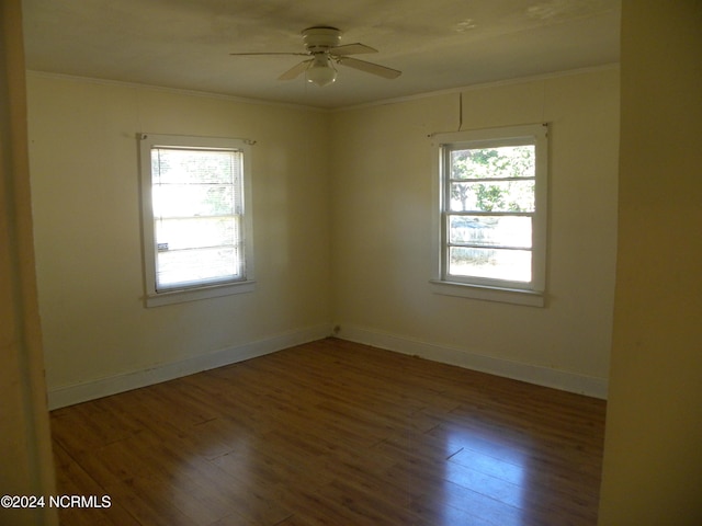 empty room with dark hardwood / wood-style floors, ceiling fan, and a wealth of natural light