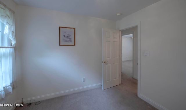 unfurnished room featuring light colored carpet