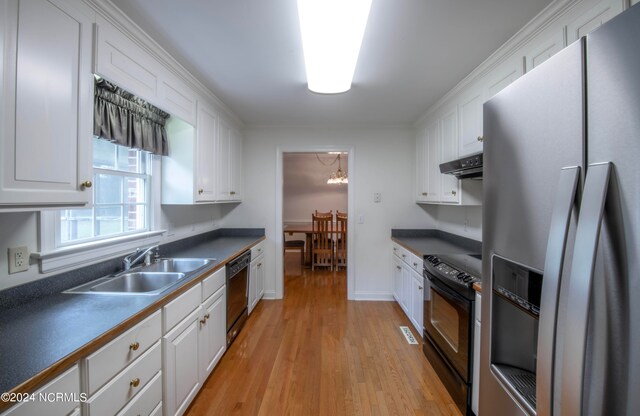 kitchen featuring sink, white cabinetry, black appliances, an inviting chandelier, and light wood-type flooring