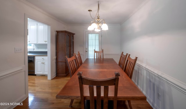 dining area featuring ornamental molding, light wood-type flooring, and a notable chandelier