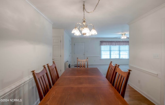 dining room with ceiling fan with notable chandelier, crown molding, and dark hardwood / wood-style flooring