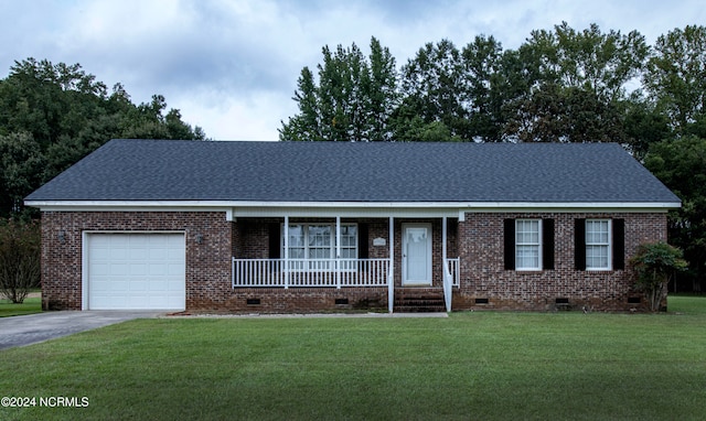 ranch-style home featuring a front lawn, covered porch, and a garage