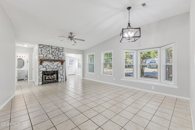 unfurnished living room with a stone fireplace, light tile patterned floors, and ceiling fan with notable chandelier