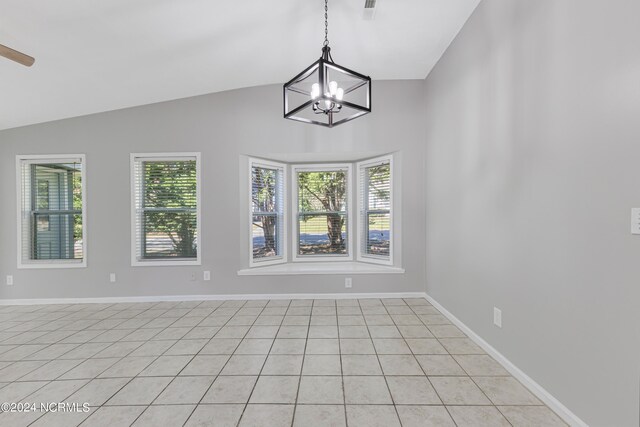 tiled empty room featuring lofted ceiling, a notable chandelier, and a healthy amount of sunlight