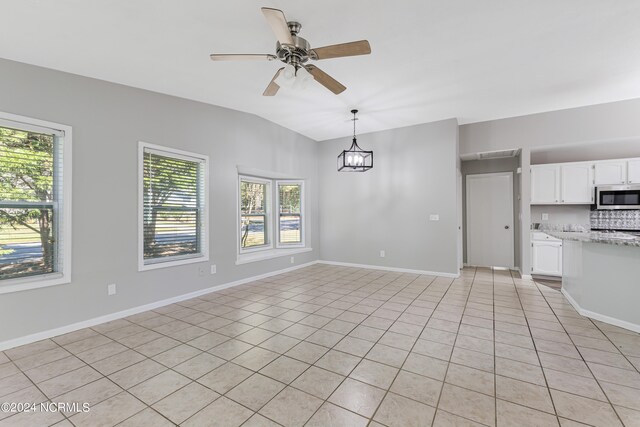 unfurnished living room featuring vaulted ceiling, light tile patterned floors, and ceiling fan with notable chandelier